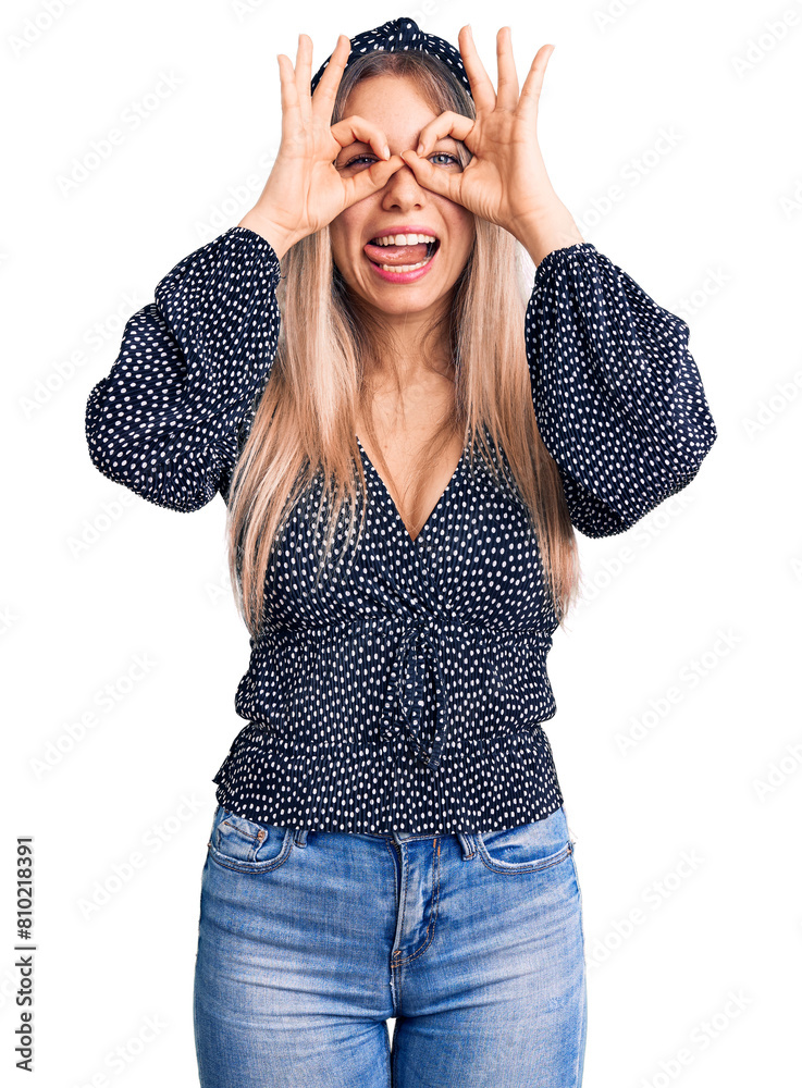 Young beautiful blonde woman wearing casual clothes doing ok gesture like binoculars sticking tongue out, eyes looking through fingers. crazy expression. Young beautiful blonde woman wearing casual clothes doing ok gesture like binoculars sticking tongue out, eyes looking through fingers. crazy expression.