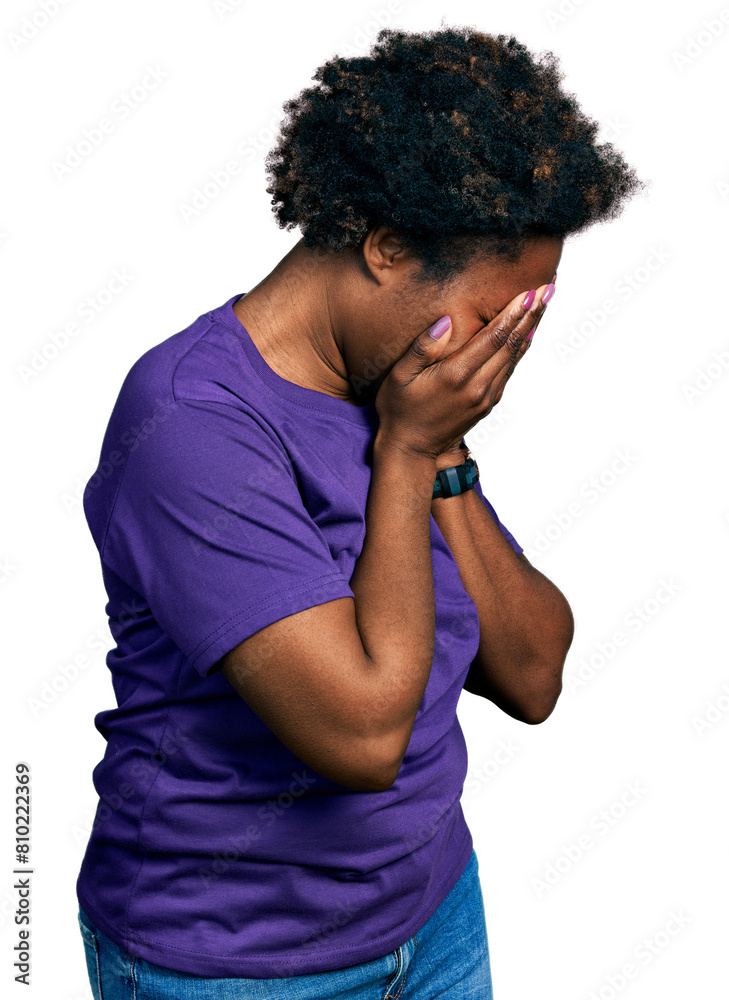 African american woman with afro hair wearing casual purple t shirt with sad expression covering face with hands while crying. depression concept. African american woman with afro hair wearing casual purple t shirt with sad expression covering face with hands while crying. depression concept.