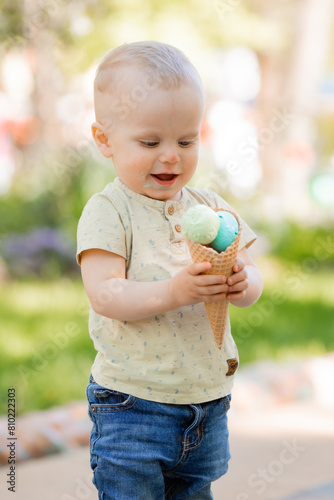 little boy eats ice cream in the park in the summer