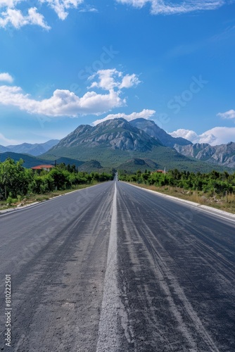 empty road with mountains in the background  Generative AI © Evghenii