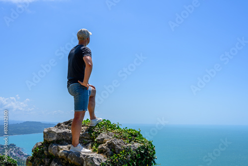 Man on the background of the Black sea and the city of New Athos in the Republic of Abkhazia photo