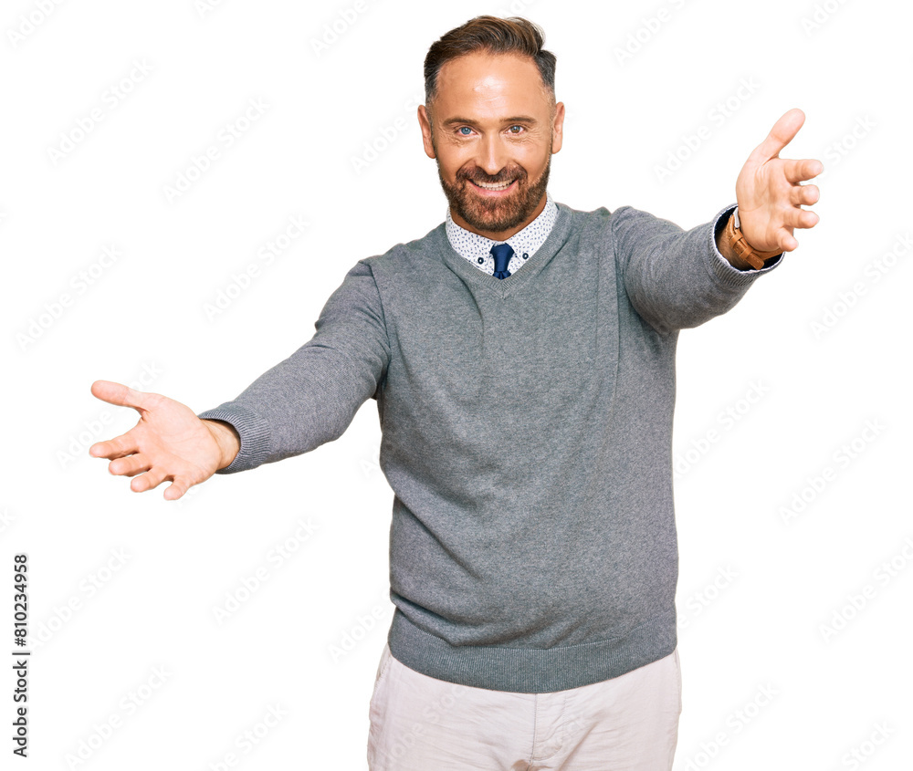 Handsome middle age man wearing business clothes looking at the camera smiling with open arms for hug. cheerful expression embracing happiness. Handsome middle age man wearing business clothes looking at the camera smiling with open arms for hug. cheerful expression embracing happiness.