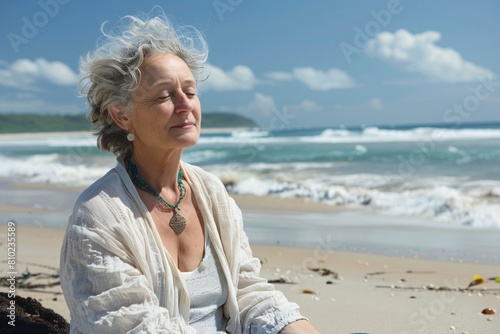 A middle-aged woman peacefully meditating on a secluded beach, attuned to the sound of waves and the salty scent of the sea breeze