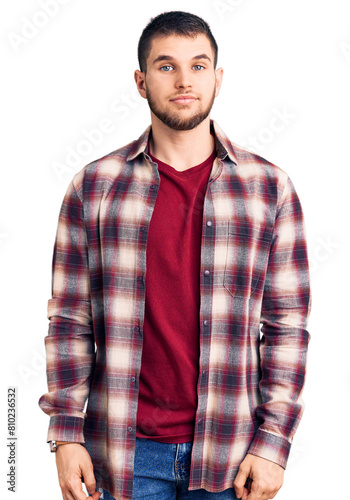 Young handsome man wearing casual shirt relaxed with serious expression on face. simple and natural looking at the camera.