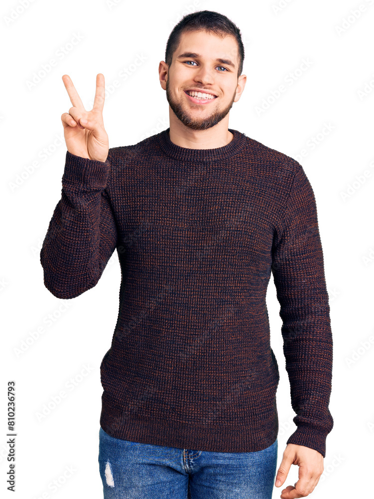 Young handsome man wearing casual sweater showing and pointing up with fingers number two while smiling confident and happy. Young handsome man wearing casual sweater showing and pointing up with fingers number two while smiling confident and happy.