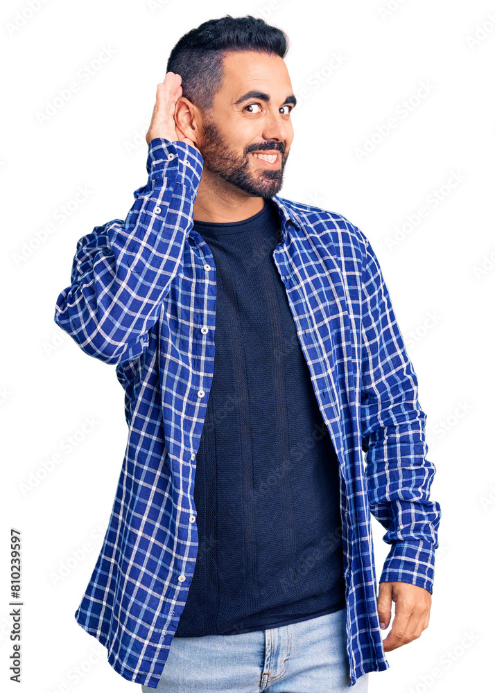 Young hispanic man wearing casual clothes smiling with hand over ear listening an hearing to rumor or gossip. deafness concept. Young hispanic man wearing casual clothes smiling with hand over ear listening an hearing to rumor or gossip. deafness concept.