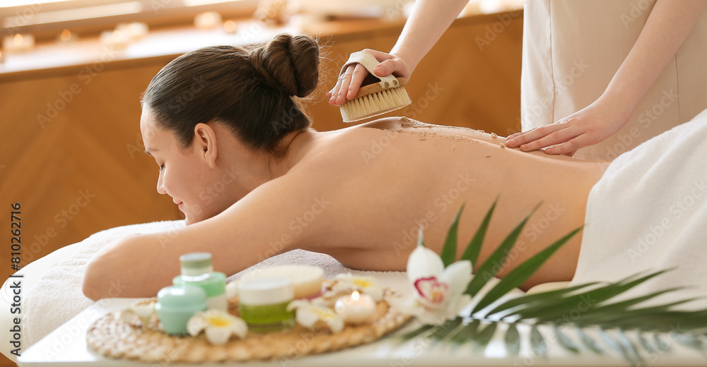Young woman receiving back scrub massage in spa salon Young woman receiving back scrub massage in spa salon