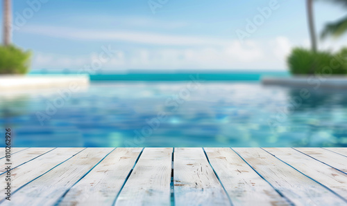 Beautiful wooden table top with a blurred background of a swimming pool and beach, conveying a summer vacation concept, banner for product display presentation in the style of summer vacation.