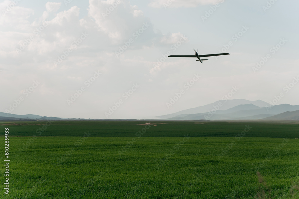 Unmanned military drone flying in the sky above the clouds, technology. Concept: military reconnaissance drone, incident in the sky, war in Ukraine. Unmanned military drone flying in the sky above the clouds, technology. Concept: military reconnaissance drone, incident in the sky, war in Ukraine.