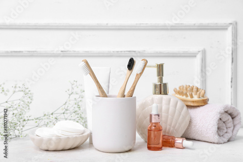 Set of different bath supplies with wooden toothbrushes on light table