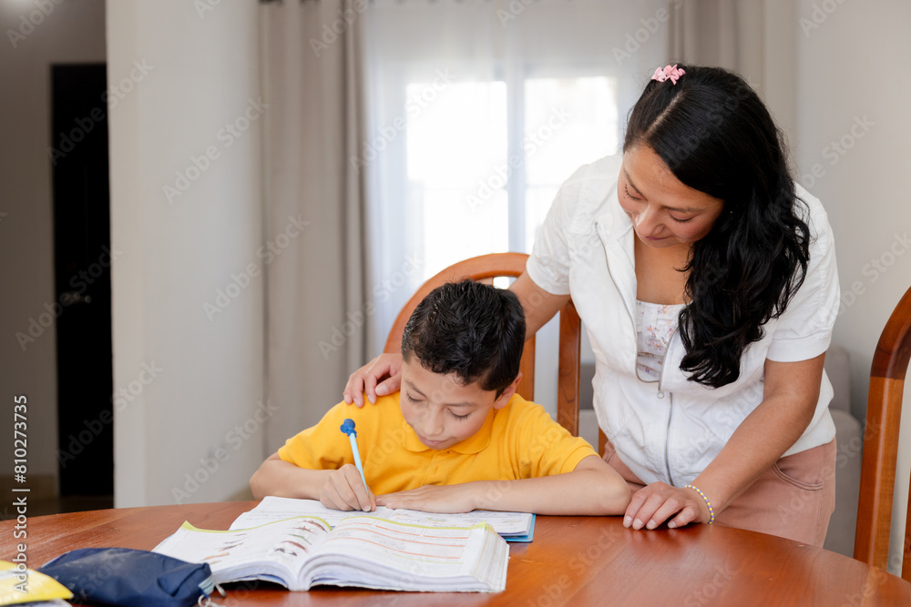 Hispanic mom helping her son do homework-mom and son studying at home ...