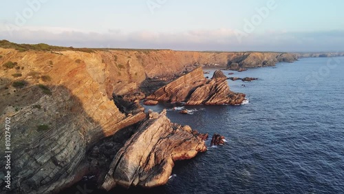 Flight over jagged rocks and cliffs at sunset. Alentejo Natural Park, Portugal photo