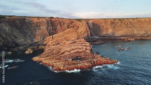 Orbiting around solitary rock in the ocean at sunset. Fishermens Trail, Portugal