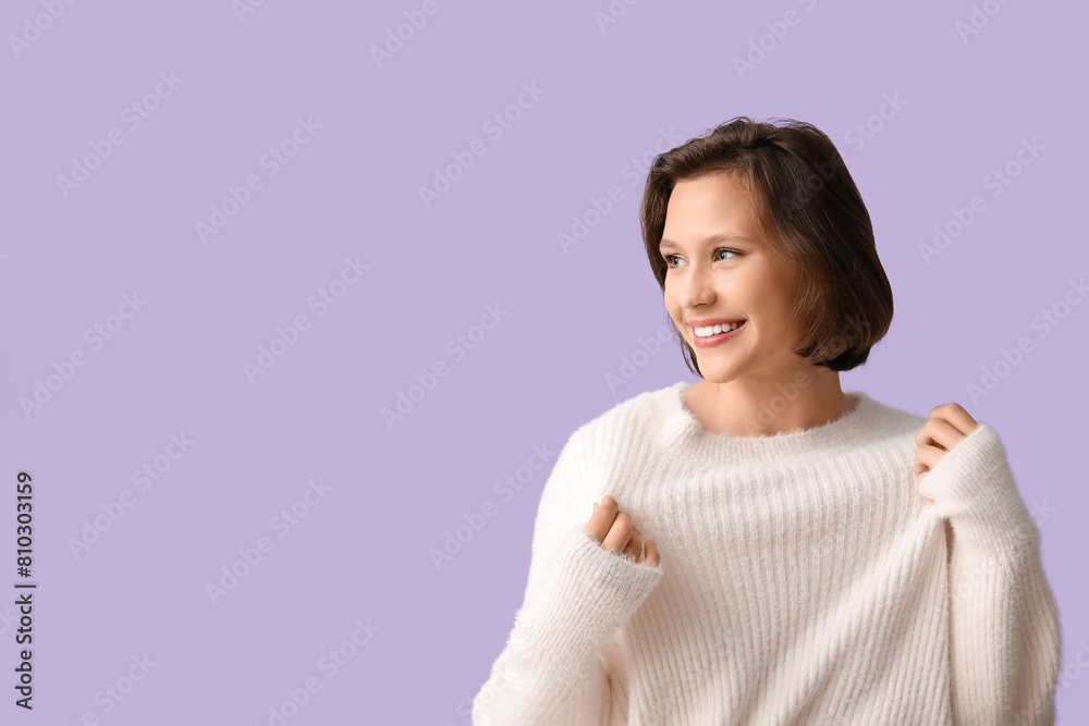 Happy young woman in stylish white sweater on lilac background Happy young woman in stylish white sweater on lilac background