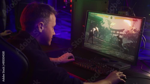 Gamer controlling a fighter in the melee combat pc simulator. Pc gamer fighting the opponent in the online video game. Pc gamer losing to the enemy fighter in the simulator match. Hobby. photo