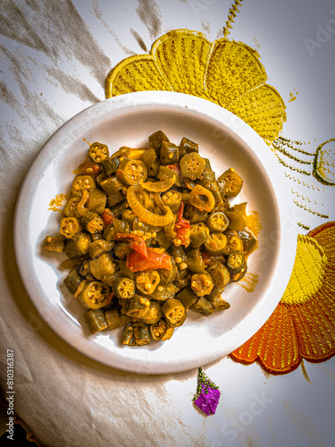 Delicious cooked okra with tomato sauce served on a porcelain plate photo