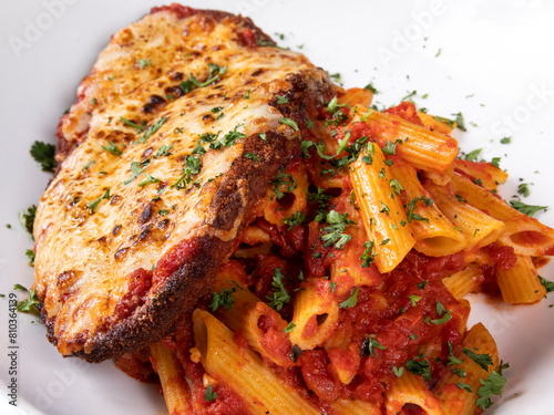 Bilde på lerret A cheese covered veal parmigiana on a bed of penne pasta with vegetable garnish