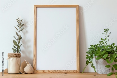 wooden brown frame with white flower on a wooden table. Houseplants nearby