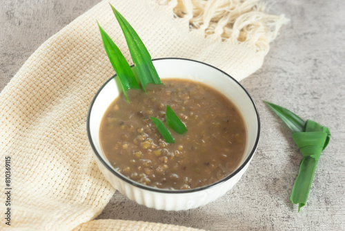 Mung Bean Porridge or Bubur Kacang Hijau, Indonesian dessert porridge of mung beans with coconut milk, pandan leaf and ginger. Served in white bowl.