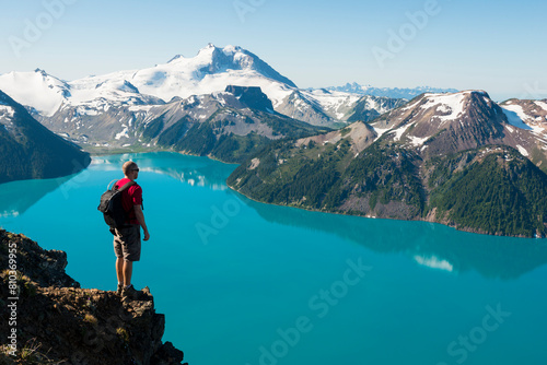 Hiker overlooking turquoise mountain lake