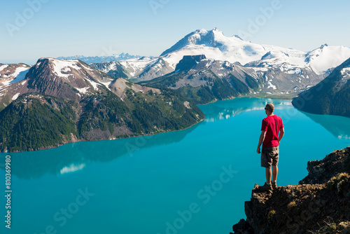 Man overlooking turquoise mountain lake