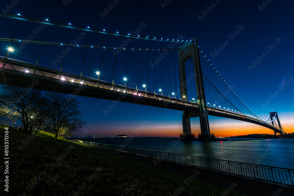 Scenic photograph capturing a suspension bridge against a dramatic twilight sky