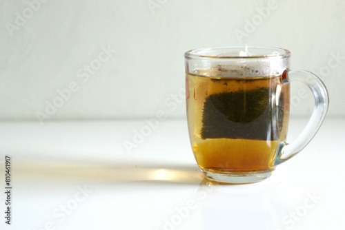 A cup of tea with tea bag on white background with copy space area, hot drink for breakfast