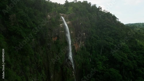 Drone majestic Diyaluma Falls cascading through Sri Lanka mountains, surrounded by plants. Aerial view waterfall height, power as water plummets into base pool, flows into forest. photo