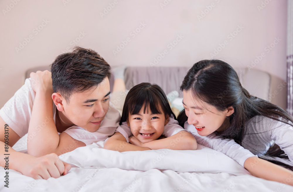 A family of three in the bed in the bedroom