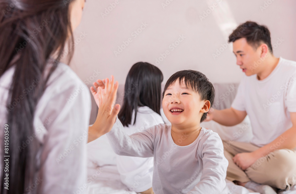 A family of four in bed in the bedroom