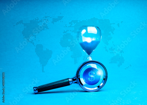 Investment online, Stock market volatility calculations, stock market timing concepts. Money coin symbol in magnifying glass lens focus on hourglass on digital world map, blue tone background.