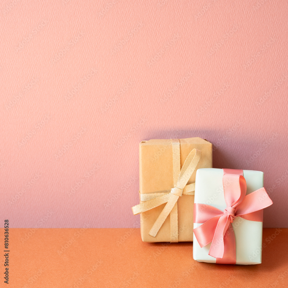 Gift boxes on orange table. pink wall background with copy space