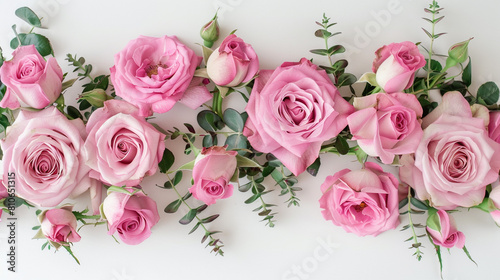 Fresh pink roses with foliage forming an organic frame on a white canvas  perfect for a romantic theme.