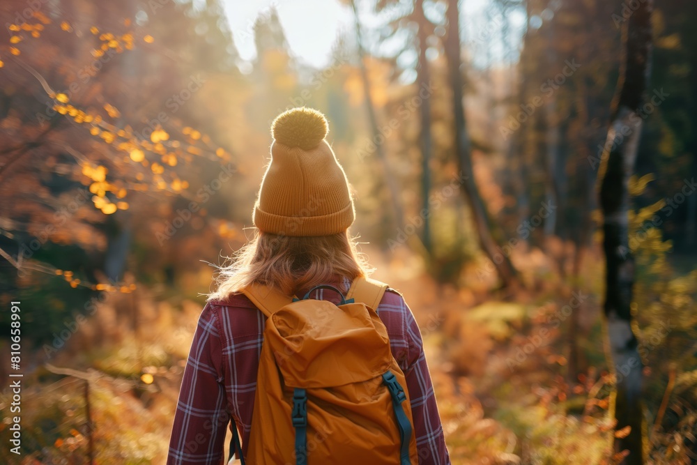 Obraz premium Hiking, a woman with a backpack walking in the woods