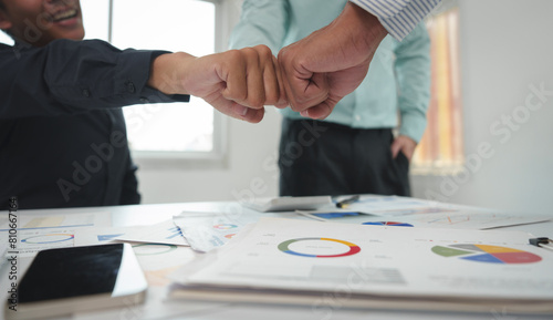 Tablou pe pânză A team of businessmen clenching their fists together agrees to work as a team to work together on finance