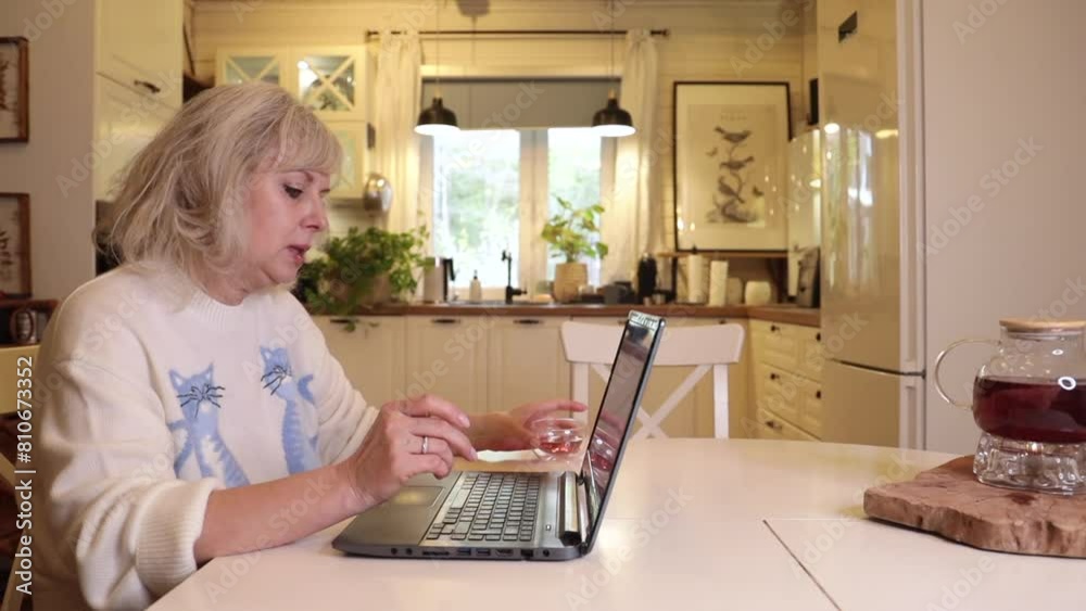 blonde woman in the kitchen working on her computer blonde woman in the kitchen working on her computer