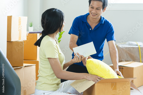 Asian couple lover unpacking thing after relocation to new apartment.