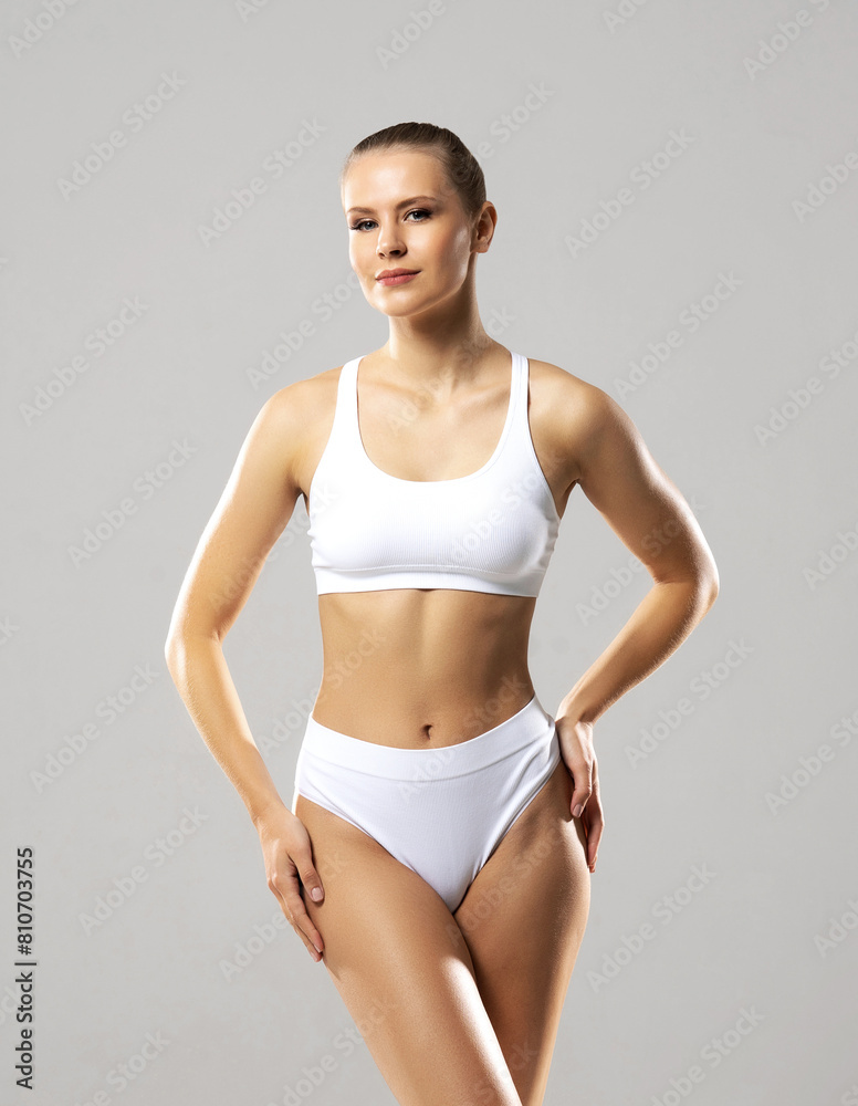 Young, fit and beautiful woman in white swimsuit over white background. The concept of healthcare, diet, sport and fitness. Young, fit and beautiful woman in white swimsuit over white background. The concept of healthcare, diet, sport and fitness.