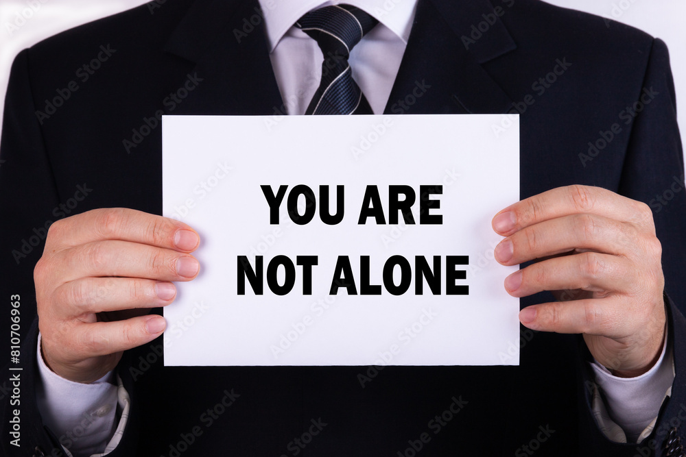 You Are Not Alone placard with bokeh background You Are Not Alone placard with bokeh background