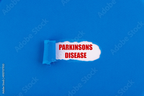 The text Parkinsons disease appearing behind torn blue paper. photo