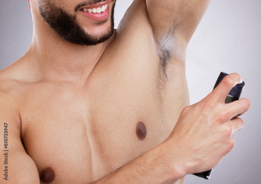 Fototapeta premium Studio, grooming and man with deodorant, smile and body care with confidence, protection and skin. Skincare, health and happy male model with spray, armpit and product isolated on grey background