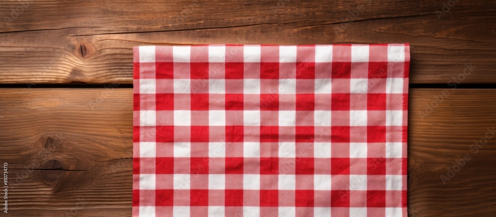 A red and white napkin is shown in a wooden background with a cage like texture creating copy space for other elements