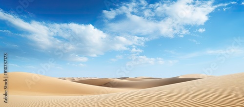 The golden desert sand and blue sky serve as a captivating backdrop in this copy space image The sand s texture and the sky s vibrant hue create a beautiful pattern that can be used as decoration or
