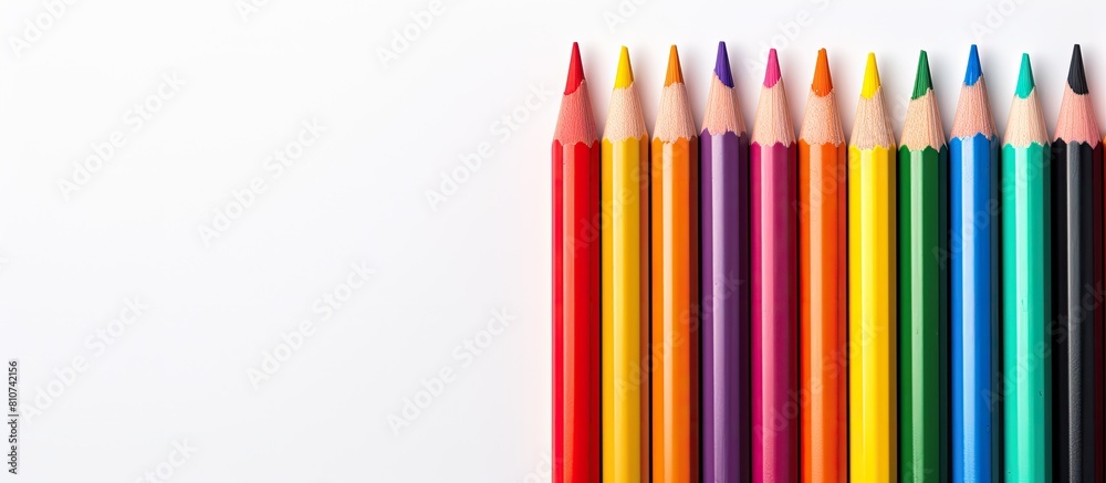 From an overhead perspective a close up image captures a collection of color pencils situated on a white background with ample space for text From an overhead perspective a close up image captures a collection of color pencils situated on a white background with ample space for text