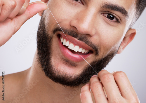Portrait  man and teeth with floss in studio for mouth care  oral hygiene and fresh breath. Morning routine  male person and smile with dental product for cavity prevention  protection and gum health