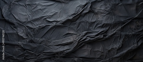 A grungy textured background with a copy space image featuring crumpled and creased black paper
