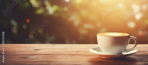Vintage tone copy space image of a white cup holding a latte coffee resting on a wooden table
