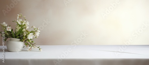 A clean white tablecloth elegantly covers a pristine wooden table creating a visually pleasing arrangement with space available for adding text or images. Creative banner. Copyspace image © HN Works