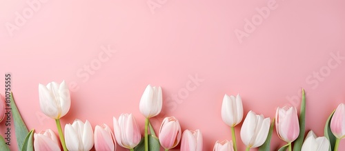 A beautiful arrangement of tulip flowers with a white horizontal greeting card placed on a pink pastel background Perfect for Mother s Day Valentine s Day or a birthday greeting Includes a blank copy