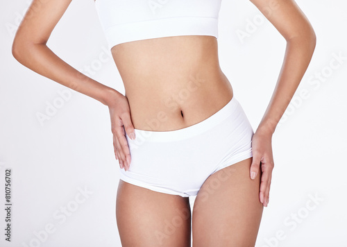 Closeup, body and woman with underwear, wellness and fitness on white studio background. Person, girl and model with panty, nutrition and exercise with gut health, beauty and workout with training © peopleimages.com